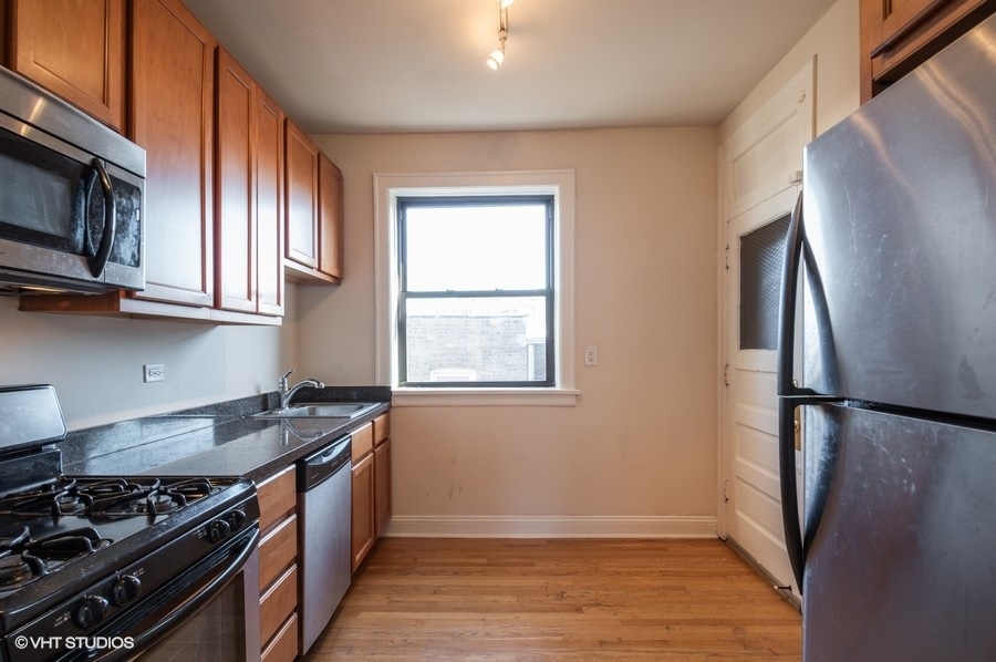 Undisclosed Address Chicago, IL 60657 - Photo 3 of 7 a kitchen with stainless steel appliances granite countertop a stove a refrigerator and a microwave