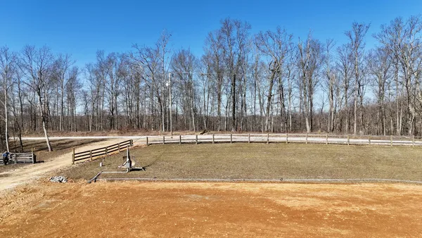 a view of a yard with trees in the background
