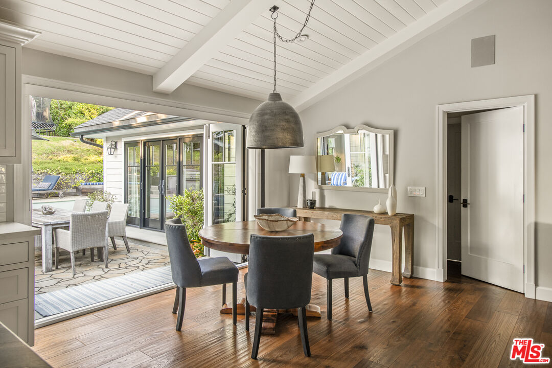 5549 Green Oak Drive Los Angeles, CA 90068 - Photo 8 of 26 a dining room with wooden floor a chandelier a glass table and chairs