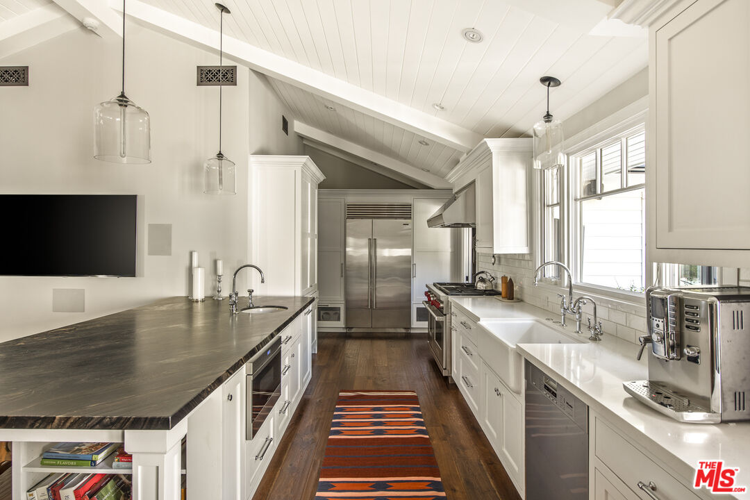 5549 Green Oak Drive Los Angeles, CA 90068 - Photo 9 of 26 a kitchen with stainless steel appliances granite countertop a sink a stove and a wooden floors