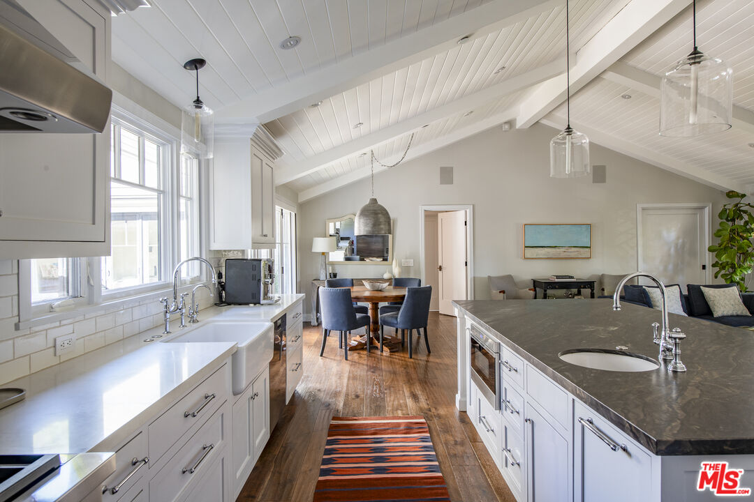 5549 Green Oak Drive Los Angeles, CA 90068 - Photo 10 of 26 a kitchen with granite countertop lots of counter space dining table and stainless steel appliances