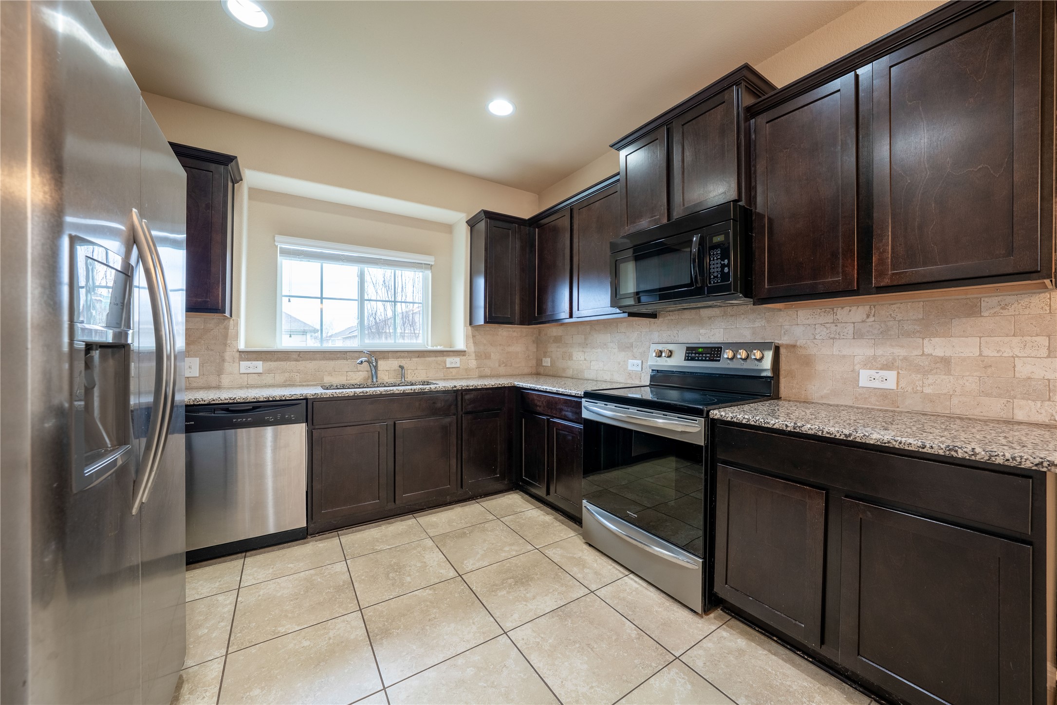 18315 Congaree Street Pflugerville, TX 78660 - Photo 1 of 1 a kitchen with stainless steel appliances granite countertop a stove a sink dishwasher a refrigerator and a microwave oven