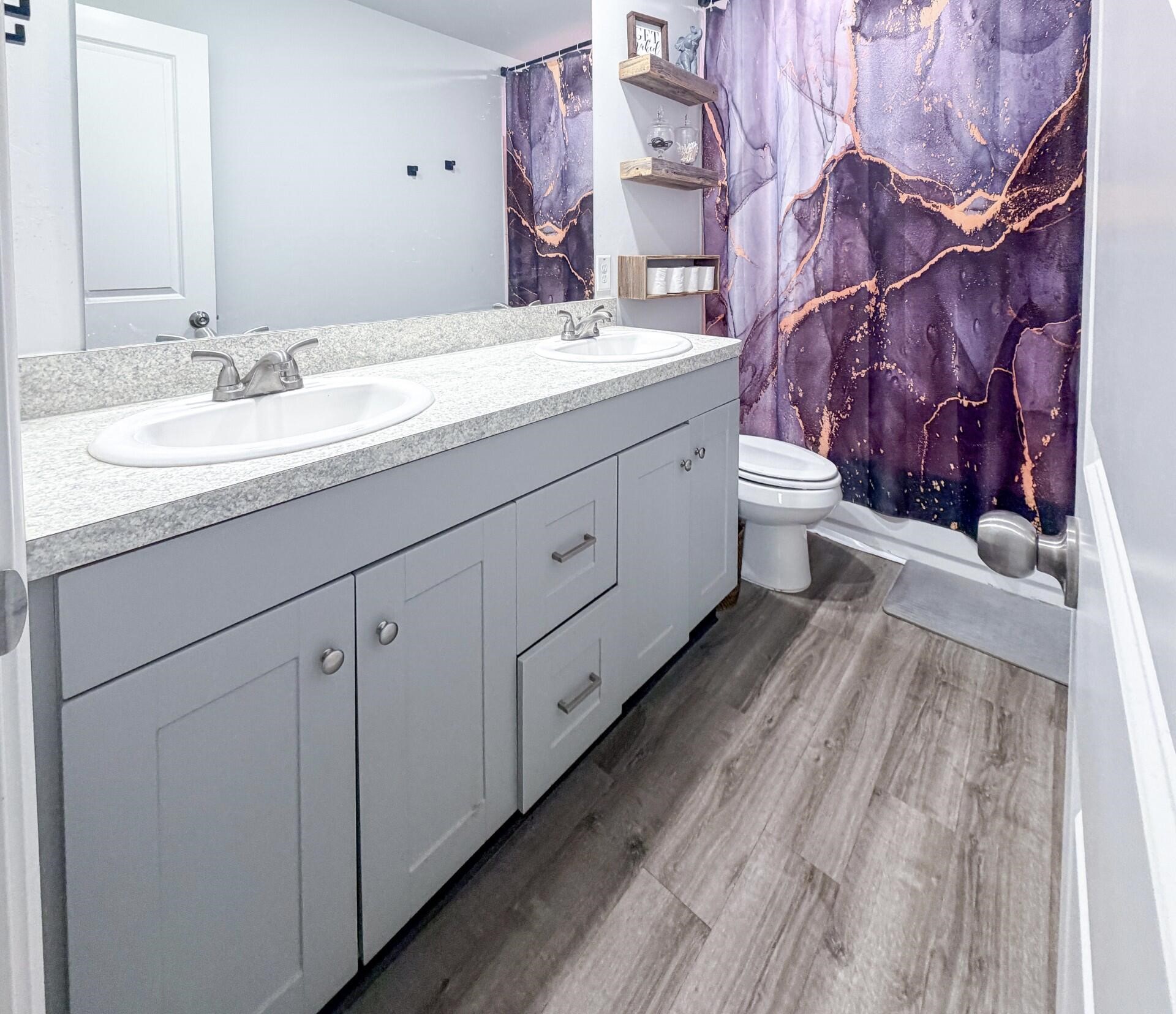 1513 22nd Street Hempstead, TX 77445 - Photo 11 of 12 a spacious bathroom with a granite countertop sink a toilet and a mirror