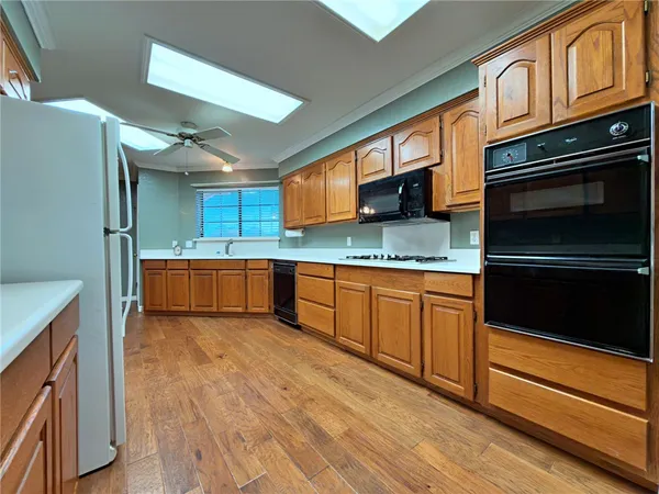 a kitchen with stainless steel appliances granite countertop a refrigerator a stove and a sink