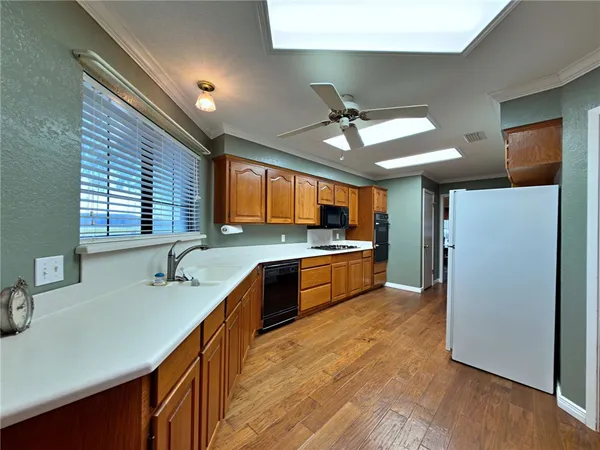 a large kitchen with stainless steel appliances granite countertop a sink a counter space cabinets and stainless steel appliances
