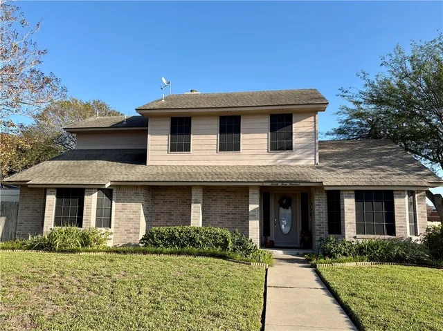 a front view of house with yard and trees