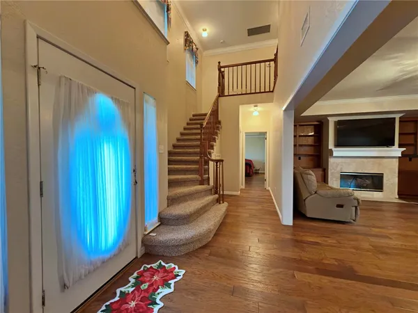 an empty room with a chandelier fan and windows