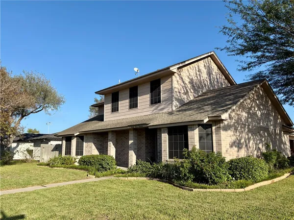 a front view of house with yard and trees