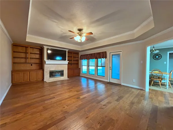 a view of empty room with wooden floor and fireplace