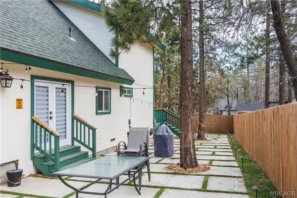 a view of a house with backyard and wooden fence
