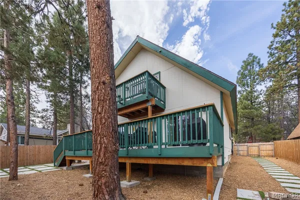a view of a house with a yard deck and furniture