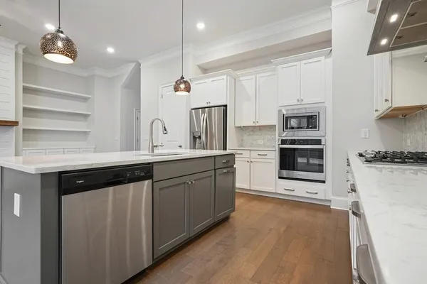 a kitchen with stainless steel appliances granite countertop a sink a stove top oven a counter space and cabinets
