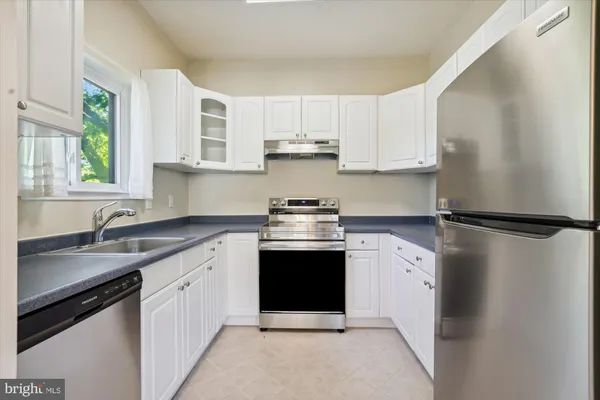 a kitchen with white cabinets and white appliances