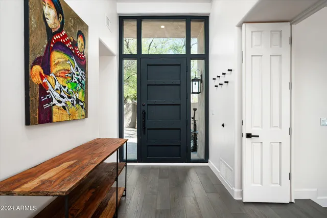a view of a hallway with wooden floor and furniture