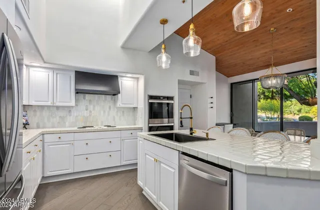 a kitchen with granite countertop a sink stainless steel appliances and cabinets
