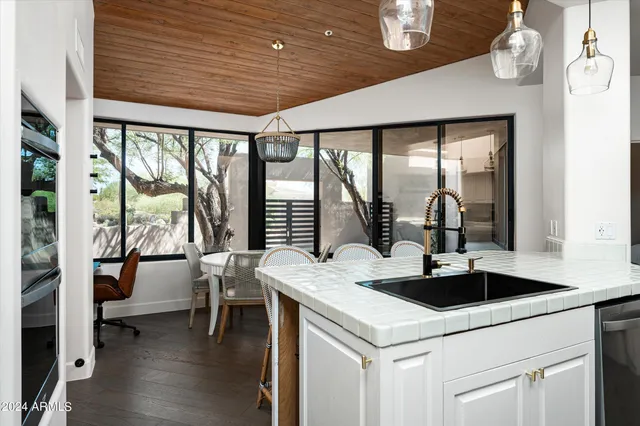a kitchen with a table chairs and wooden floor