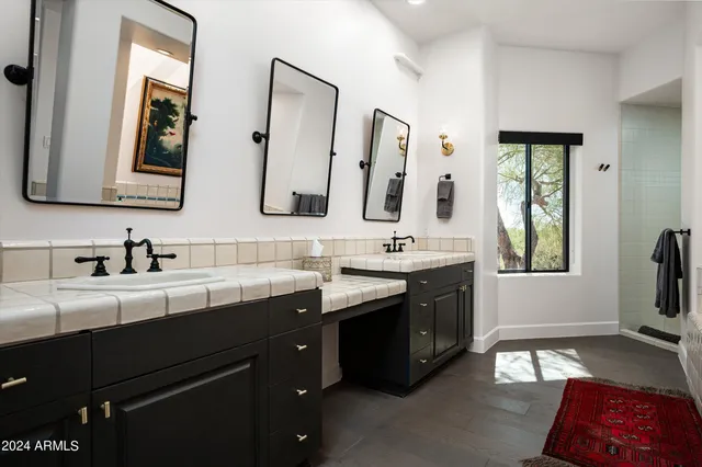 a bathroom with a double vanity sink a mirror and a bathtub