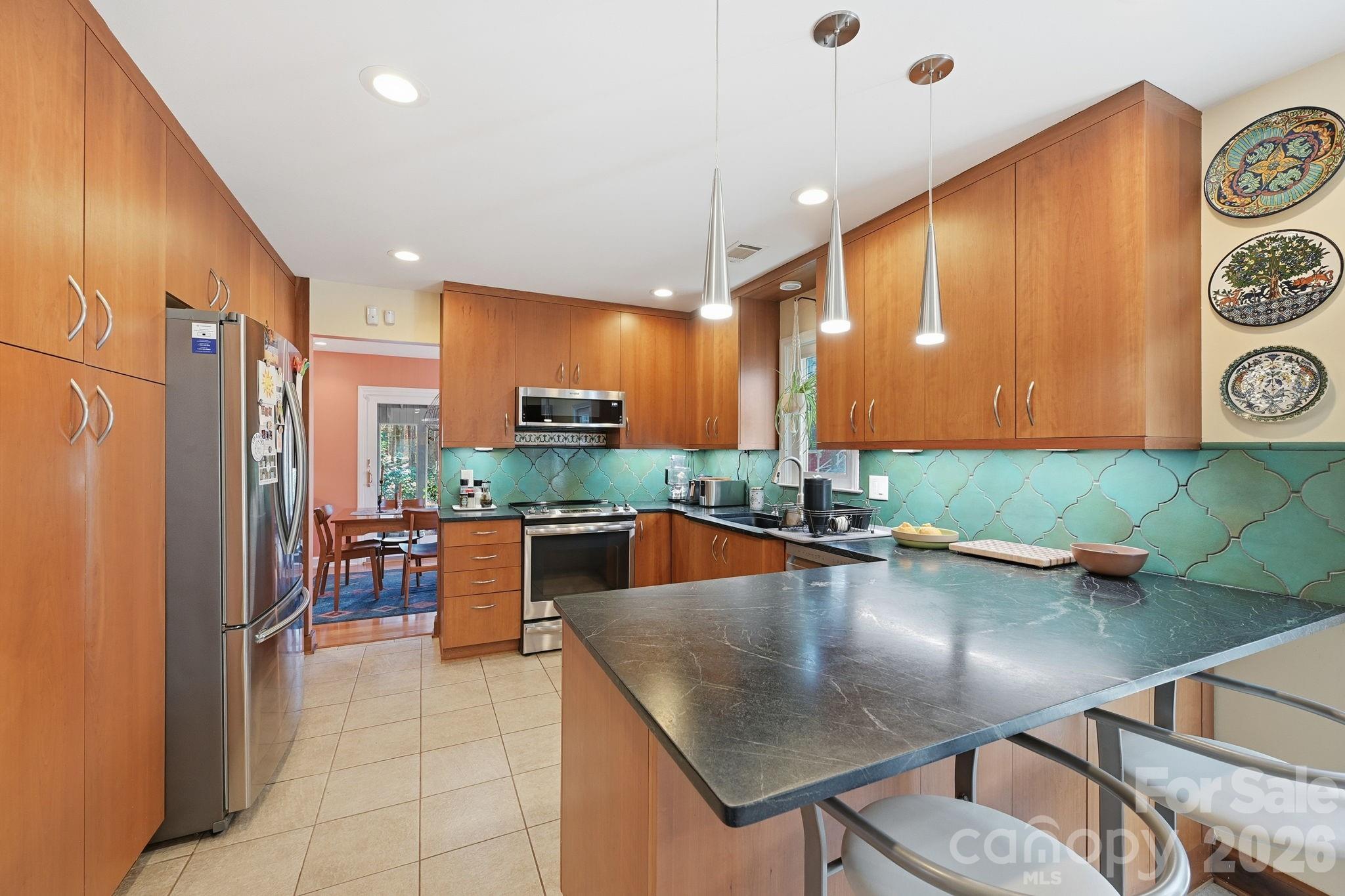 1916 Davis Road Davidson, NC 28036 - Photo 13 of 45 a kitchen with stainless steel appliances granite countertop a sink a stove and a refrigerator