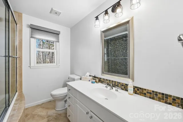 a bathroom with a sink mirror and a toilet