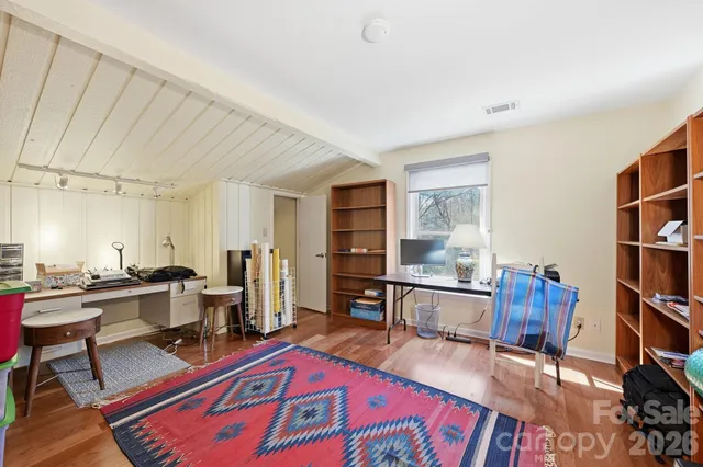 a living room with furniture a rug and a bookshelf