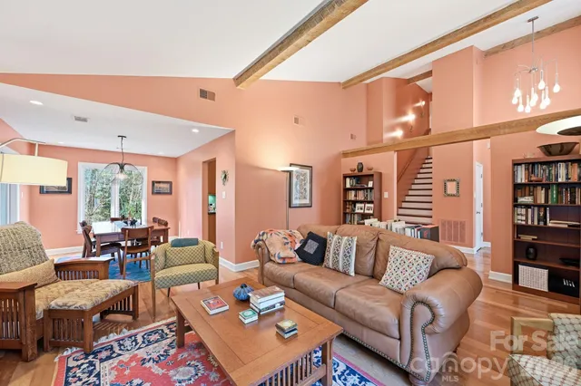 a living room with furniture a bookshelf and a large window