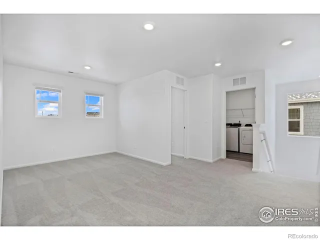 a view of empty room with kitchen