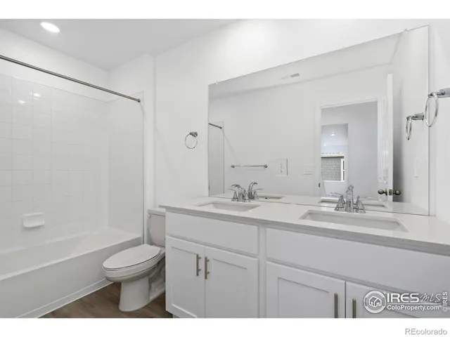 a bathroom with a granite countertop sink toilet a large mirror a shower and a bathtub