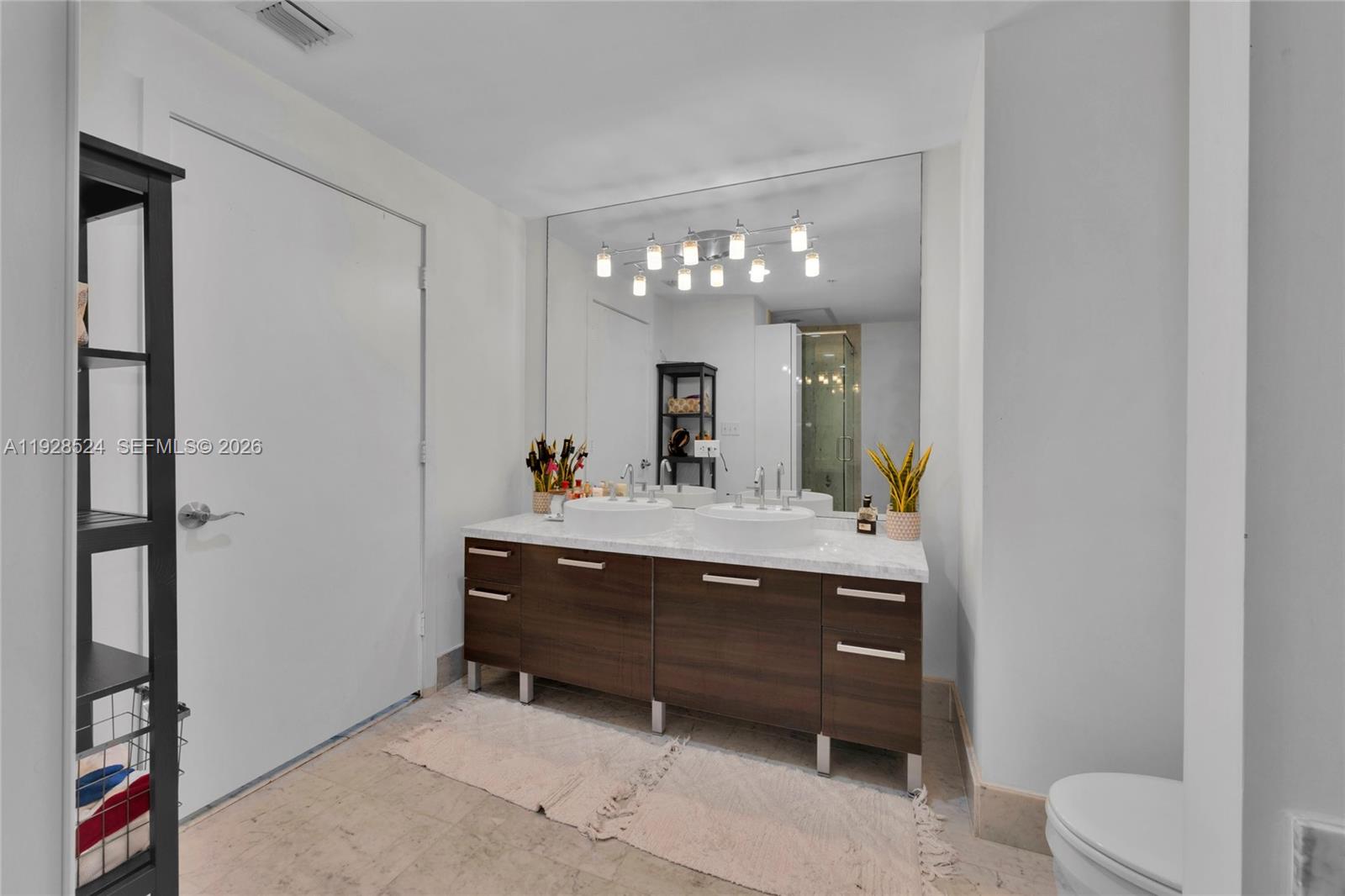 253 Northeast 2nd Street, Unit 1710 Miami, FL 33132 - Photo 13 of 22 a bathroom with a sink vanity and a mirror