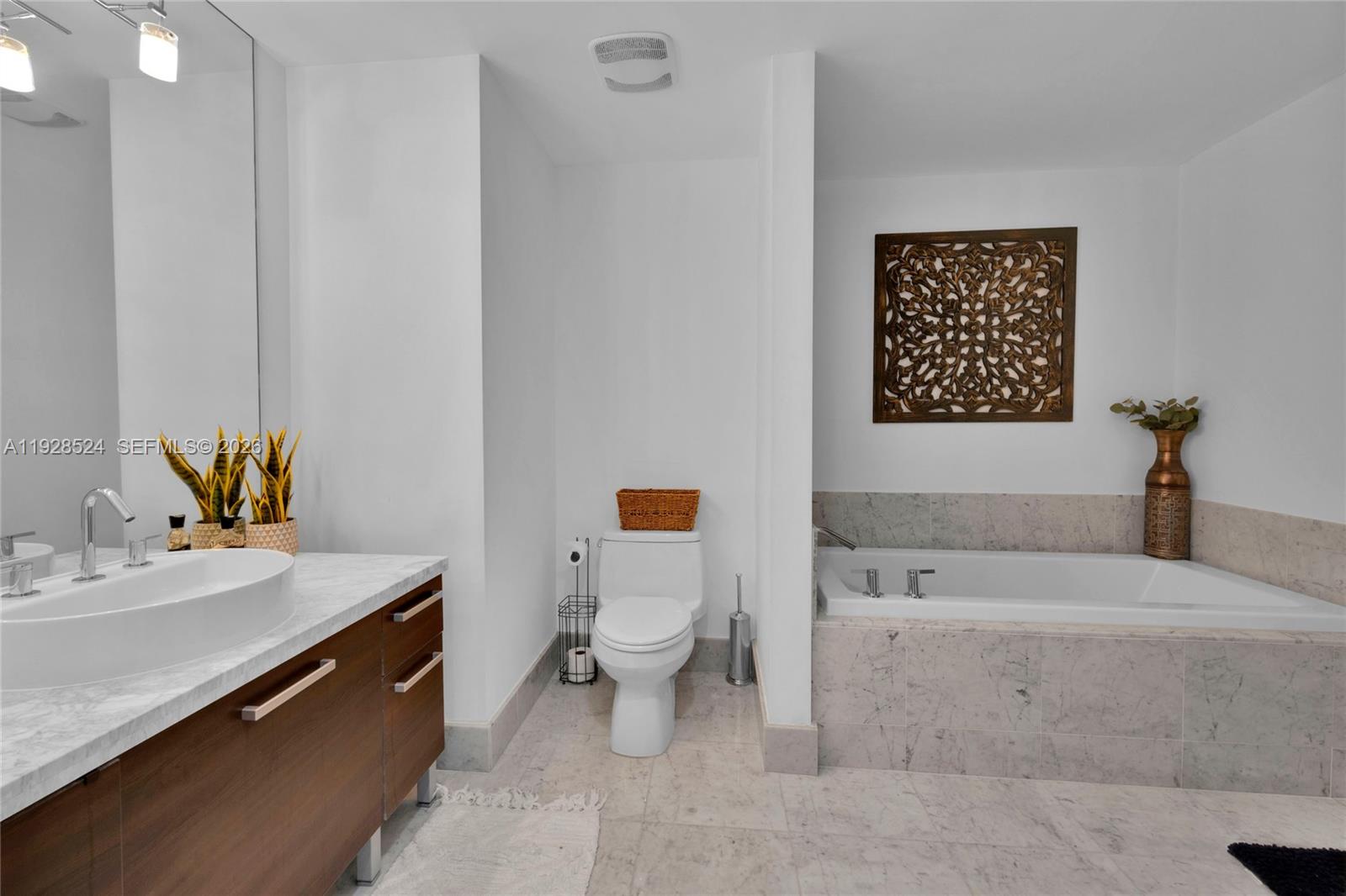 253 Northeast 2nd Street, Unit 1710 Miami, FL 33132 - Photo 14 of 22 a bathroom with a sink a toilet and mirror