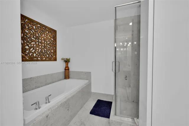 a bathroom with a tub shower and sink