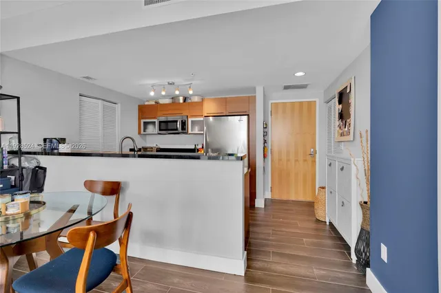 a kitchen with stainless steel appliances granite countertop a refrigerator and a stove top oven