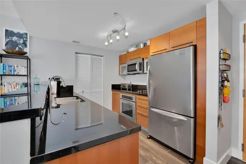 a kitchen with stainless steel appliances granite countertop a refrigerator and a stove
