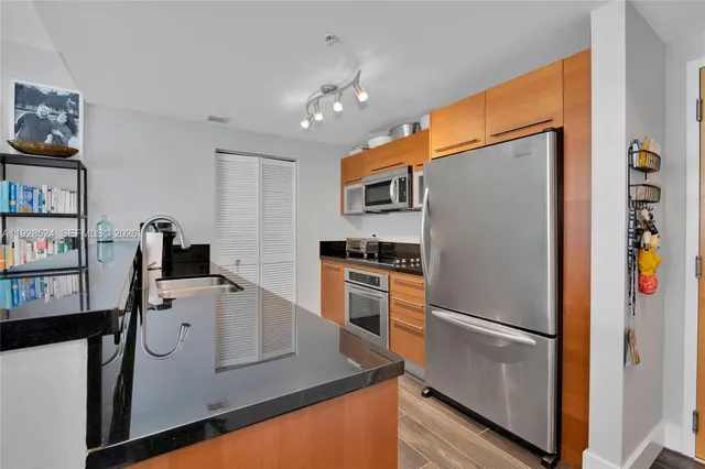 a kitchen with stainless steel appliances granite countertop a refrigerator and a stove