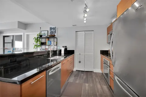 a kitchen with granite countertop stainless steel appliances and wooden cabinets