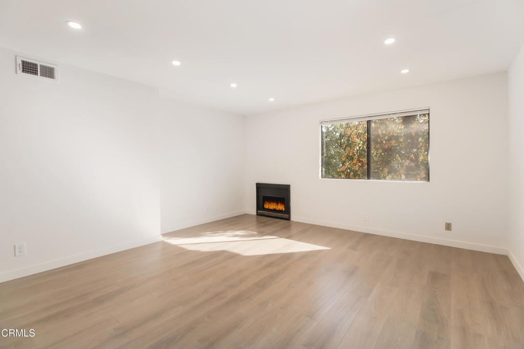 1169 Rosedale Avenue, Unit 204 Glendale, CA 91201 - Photo 3 of 27 an empty room with wooden floor and windows