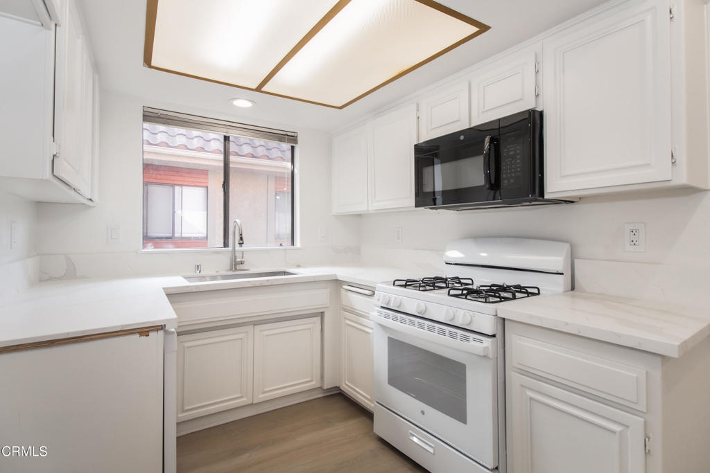 1169 Rosedale Avenue, Unit 204 Glendale, CA 91201 - Photo 8 of 27 a kitchen with stainless steel appliances white cabinets and white appliances