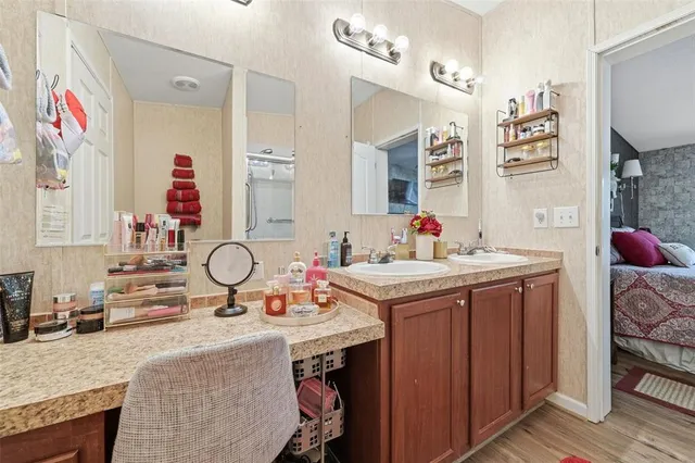 a bathroom with a granite countertop sink a mirror and a shower