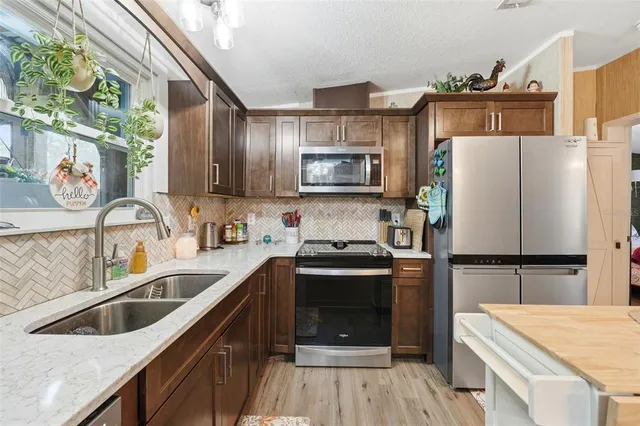 a kitchen with stainless steel appliances granite countertop a sink stove and refrigerator