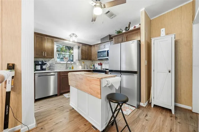 a kitchen with kitchen island white cabinets and stainless steel appliances