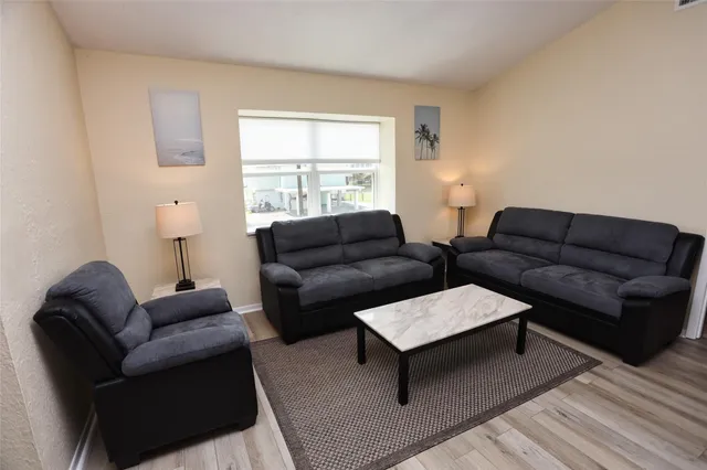 a living room with furniture a flat screen tv and a window