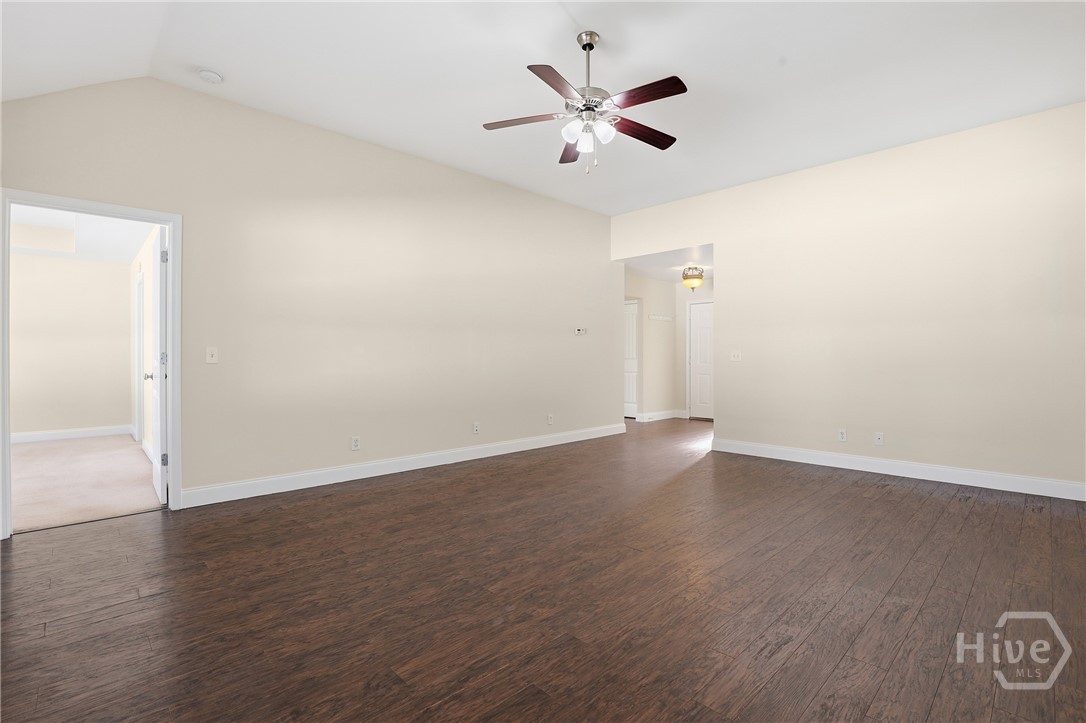 130 Terraza Lane Savannah, GA 31405 - Photo 6 of 31 Big Open Living Room With Vaulted Ceiling, Laminate Wood Floors and Ceiling Fan. Door on the left leads to Primary Suite.