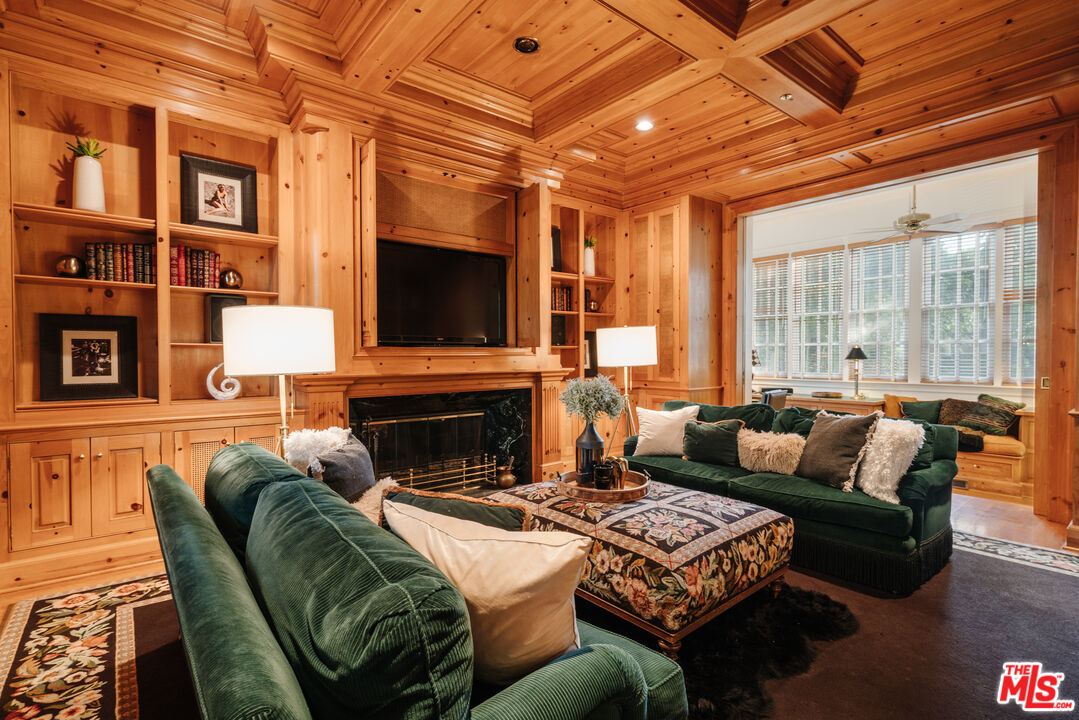 4261 Ledge Avenue Toluca Lake, CA 91602 - Photo 12 of 49 a living room with furniture a fireplace and a flat screen tv
