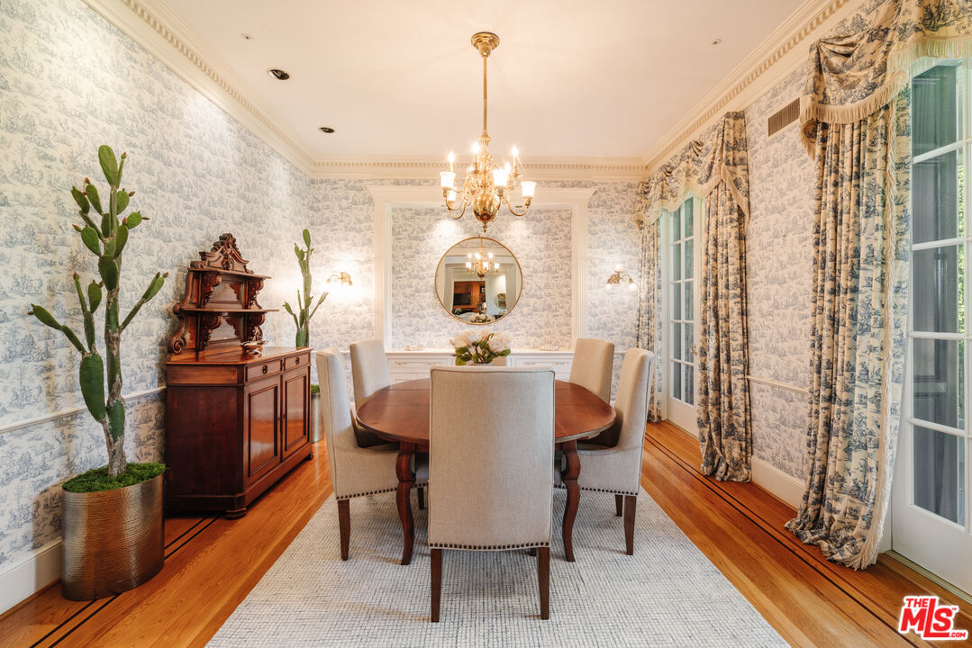4261 Ledge Avenue Toluca Lake, CA 91602 - Photo 16 of 49 a dining room with furniture a chandelier and wooden floor