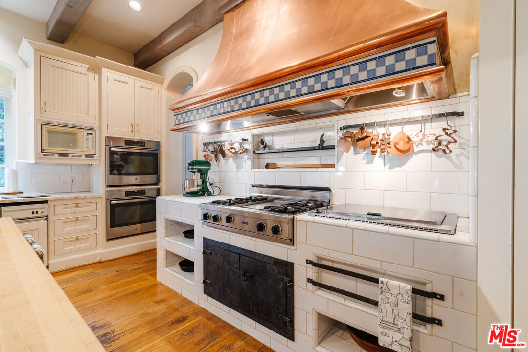 4261 Ledge Avenue Toluca Lake, CA 91602 - Photo 19 of 49 a kitchen with stainless steel appliances a stove and a refrigerator