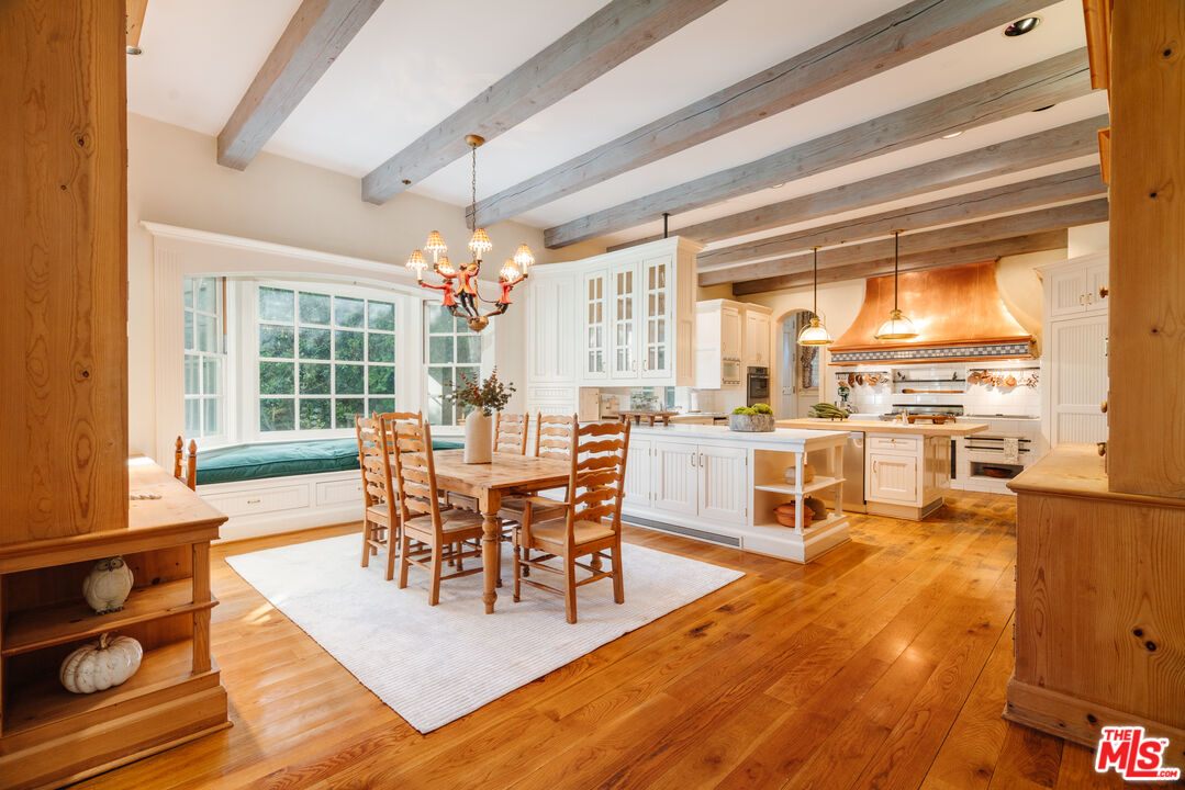 4261 Ledge Avenue Toluca Lake, CA 91602 - Photo 22 of 49 a dining room with furniture a chandelier and wooden floor