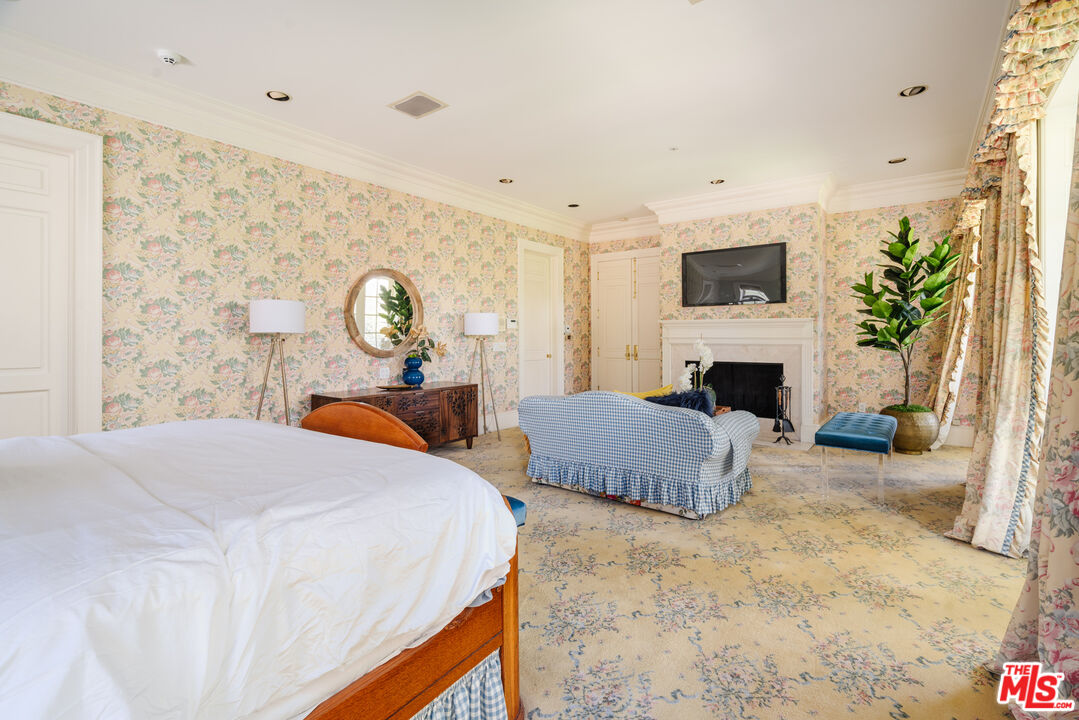 4261 Ledge Avenue Toluca Lake, CA 91602 - Photo 31 of 49 a bedroom with bed and a fireplace