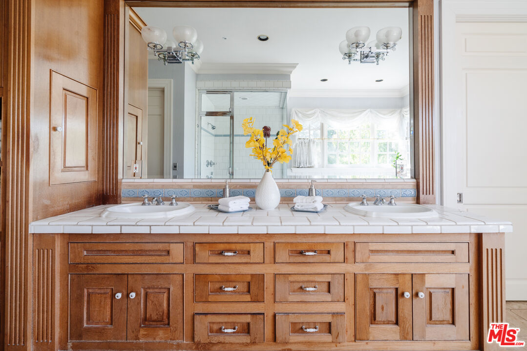 4261 Ledge Avenue Toluca Lake, CA 91602 - Photo 34 of 49 a bathroom with a granite countertop sink and a large mirror