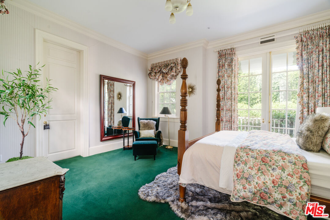 4261 Ledge Avenue Toluca Lake, CA 91602 - Photo 42 of 49 a spacious bedroom with a bed table chair and a window