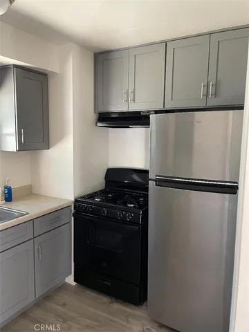 a kitchen with a refrigerator and a stove top oven