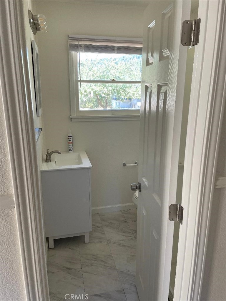 23689 Manzanita Drive, Unit 3 Crestline, CA 92325 - Photo 5 of 5 a bathroom with a sink a window and shower